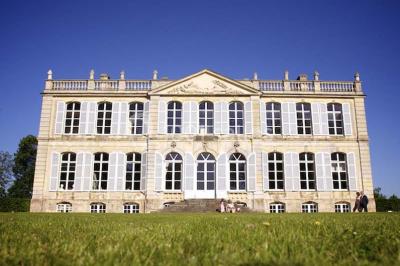 Écran lumineux affichant des images colorées dans un jardin fleuri à la tombée de la nuit.