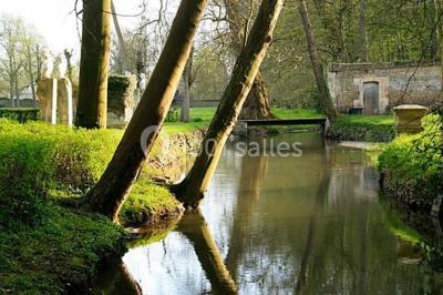 Écran lumineux affichant des images colorées dans un jardin fleuri à la tombée de la nuit.