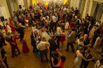 Écran lumineux affichant des images colorées dans un jardin fleuri à la tombée de la nuit.