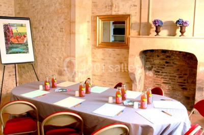 Écran lumineux affichant des images colorées dans un jardin fleuri à la tombée de la nuit.