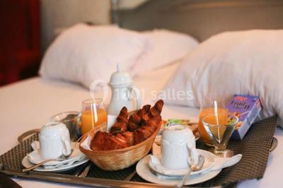 Façade d'un hôtel ancien à plusieurs étages, avec des fenêtres symétriques et un ciel bleu dégagé en arrière-plan.