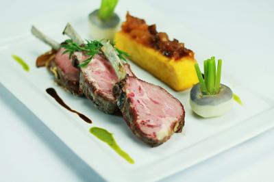 Façade d'un hôtel ancien à plusieurs étages, avec des fenêtres symétriques et un ciel bleu dégagé en arrière-plan.