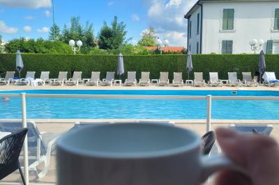 Façade d'un hôtel ancien à plusieurs étages, avec des fenêtres symétriques et un ciel bleu dégagé en arrière-plan.