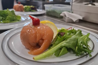 Salle de conférence lumineuse avec tables disposées en U, écran de projection et grandes fenêtres donnant sur l'extérieur.