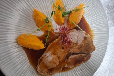 Salle de conférence lumineuse avec tables disposées en U, écran de projection et grandes fenêtres donnant sur l'extérieur.