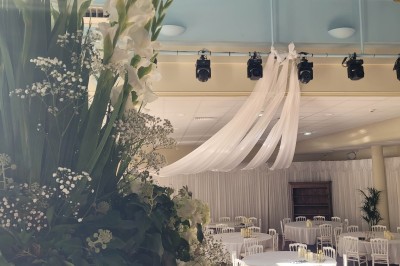 Salle de conférence lumineuse avec tables disposées en U, écran de projection et grandes fenêtres donnant sur l'extérieur.