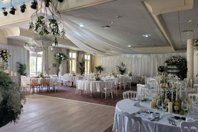 Salle de conférence lumineuse avec tables disposées en U, écran de projection et grandes fenêtres donnant sur l'extérieur.