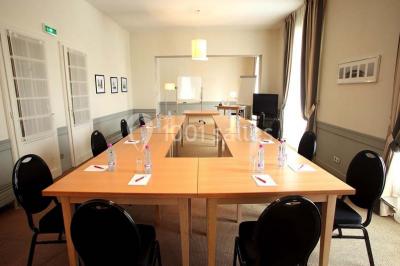 Façade d'un hôtel ancien à plusieurs étages, avec des fenêtres symétriques et un ciel bleu dégagé en arrière-plan.