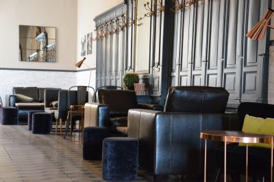 Façade d'un hôtel ancien à plusieurs étages, avec des fenêtres symétriques et un ciel bleu dégagé en arrière-plan.