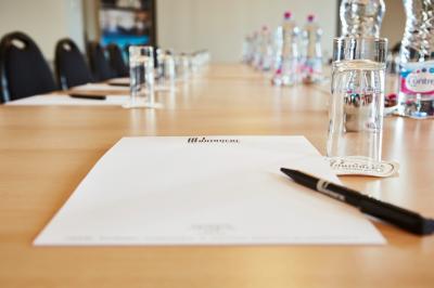 Façade d'un hôtel ancien à plusieurs étages, avec des fenêtres symétriques et un ciel bleu dégagé en arrière-plan.