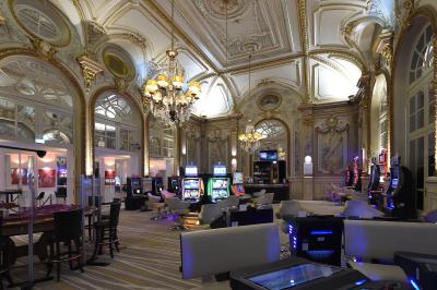 Façade d'un hôtel ancien à plusieurs étages, avec des fenêtres symétriques et un ciel bleu dégagé en arrière-plan.