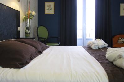 Façade d'un hôtel ancien à plusieurs étages, avec des fenêtres symétriques et un ciel bleu dégagé en arrière-plan.