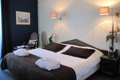 Façade d'un hôtel ancien à plusieurs étages, avec des fenêtres symétriques et un ciel bleu dégagé en arrière-plan.