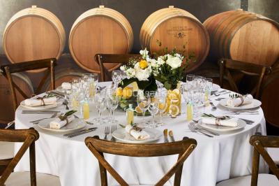 Un couple en tenue de mariage se tient devant une porte illuminée, entouré de briques et de végétation.