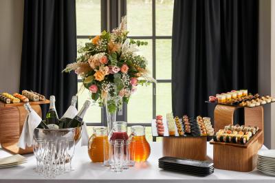 Un couple en tenue de mariage se tient devant une porte illuminée, entouré de briques et de végétation.