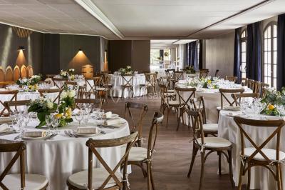 Un couple en tenue de mariage se tient devant une porte illuminée, entouré de briques et de végétation.