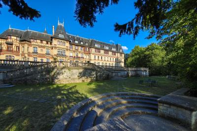 Un couple en tenue de mariage se tient devant une porte illuminée, entouré de briques et de végétation.