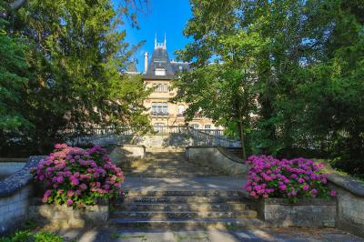 Un couple en tenue de mariage se tient devant une porte illuminée, entouré de briques et de végétation.
