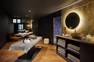 Un couple en tenue de mariage se tient devant une porte illuminée, entouré de briques et de végétation.