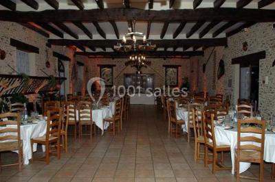 Espace extérieur avec balançoire, table et chaises blanches, parterre de fleurs rouges et jouet en plastique jaune.