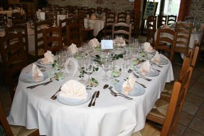 Espace extérieur avec balançoire, table et chaises blanches, parterre de fleurs rouges et jouet en plastique jaune.