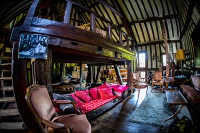 Table de ping-pong dans une pièce lumineuse avec canapé, fauteuil, décorations murales et fenêtres donnant sur la verdure.