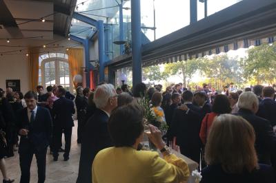 Table de ping-pong dans une pièce lumineuse avec canapé, fauteuil, décorations murales et fenêtres donnant sur la verdure.