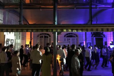 Table de ping-pong dans une pièce lumineuse avec canapé, fauteuil, décorations murales et fenêtres donnant sur la verdure.