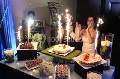 Buffet de petit-déjeuner avec viennoiseries, confitures, pains et boissons, près d'une baie vitrée donnant sur un jardin.