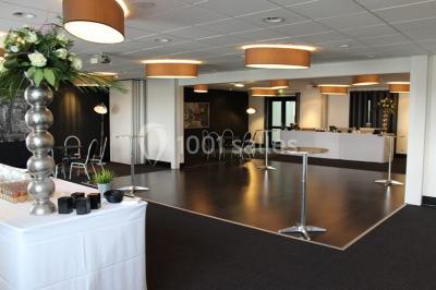 Buffet de petit-déjeuner avec viennoiseries, confitures, pains et boissons, près d'une baie vitrée donnant sur un jardin.