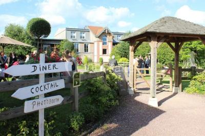 Buffet de petit-déjeuner avec viennoiseries, confitures, pains et boissons, près d'une baie vitrée donnant sur un jardin.