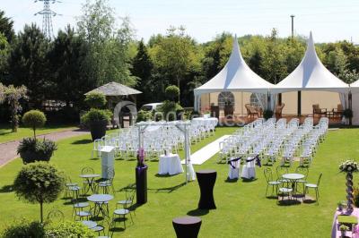 Buffet de petit-déjeuner avec viennoiseries, confitures, pains et boissons, près d'une baie vitrée donnant sur un jardin.