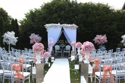 Buffet de petit-déjeuner avec viennoiseries, confitures, pains et boissons, près d'une baie vitrée donnant sur un jardin.