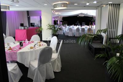 Buffet de petit-déjeuner avec viennoiseries, confitures, pains et boissons, près d'une baie vitrée donnant sur un jardin.