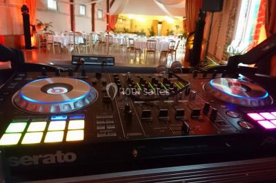 Buffet de petit-déjeuner avec viennoiseries, confitures, pains et boissons, près d'une baie vitrée donnant sur un jardin.