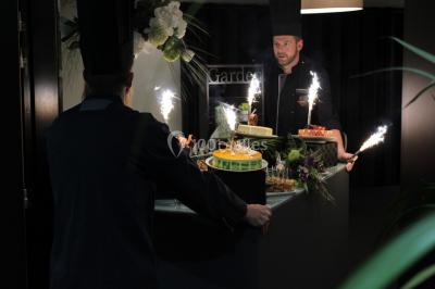 Buffet de petit-déjeuner avec viennoiseries, confitures, pains et boissons, près d'une baie vitrée donnant sur un jardin.