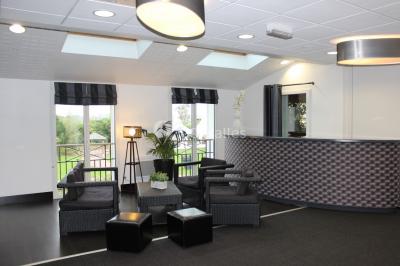 Buffet de petit-déjeuner avec viennoiseries, confitures, pains et boissons, près d'une baie vitrée donnant sur un jardin.