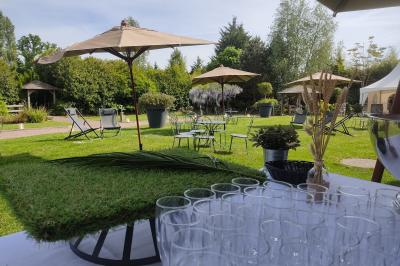 Buffet de petit-déjeuner avec viennoiseries, confitures, pains et boissons, près d'une baie vitrée donnant sur un jardin.