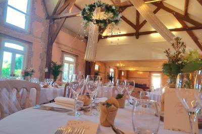 Buffet de petit-déjeuner avec viennoiseries, confitures, pains et boissons, près d'une baie vitrée donnant sur un jardin.