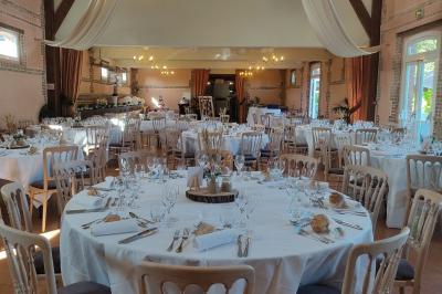 Buffet de petit-déjeuner avec viennoiseries, confitures, pains et boissons, près d'une baie vitrée donnant sur un jardin.