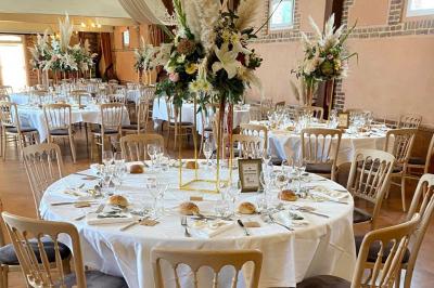 Buffet de petit-déjeuner avec viennoiseries, confitures, pains et boissons, près d'une baie vitrée donnant sur un jardin.