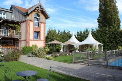 Buffet de petit-déjeuner avec viennoiseries, confitures, pains et boissons, près d'une baie vitrée donnant sur un jardin.