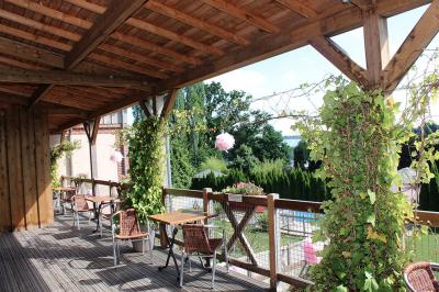 Buffet de petit-déjeuner avec viennoiseries, confitures, pains et boissons, près d'une baie vitrée donnant sur un jardin.