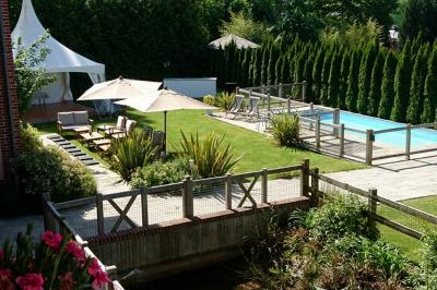 Buffet de petit-déjeuner avec viennoiseries, confitures, pains et boissons, près d'une baie vitrée donnant sur un jardin.