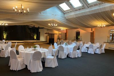 Buffet de petit-déjeuner avec viennoiseries, confitures, pains et boissons, près d'une baie vitrée donnant sur un jardin.