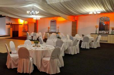 Buffet de petit-déjeuner avec viennoiseries, confitures, pains et boissons, près d'une baie vitrée donnant sur un jardin.