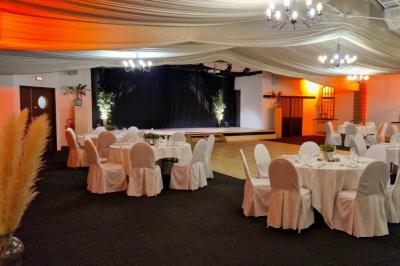 Buffet de petit-déjeuner avec viennoiseries, confitures, pains et boissons, près d'une baie vitrée donnant sur un jardin.