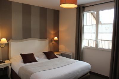 Buffet de petit-déjeuner avec viennoiseries, confitures, pains et boissons, près d'une baie vitrée donnant sur un jardin.