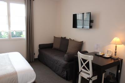 Buffet de petit-déjeuner avec viennoiseries, confitures, pains et boissons, près d'une baie vitrée donnant sur un jardin.