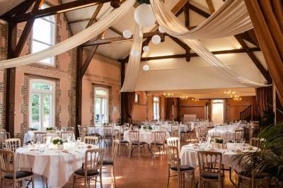 Buffet de petit-déjeuner avec viennoiseries, confitures, pains et boissons, près d'une baie vitrée donnant sur un jardin.